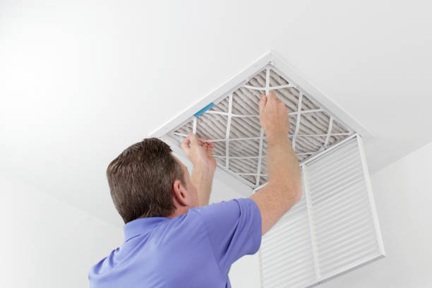 Technician replacing ceiling vent filter