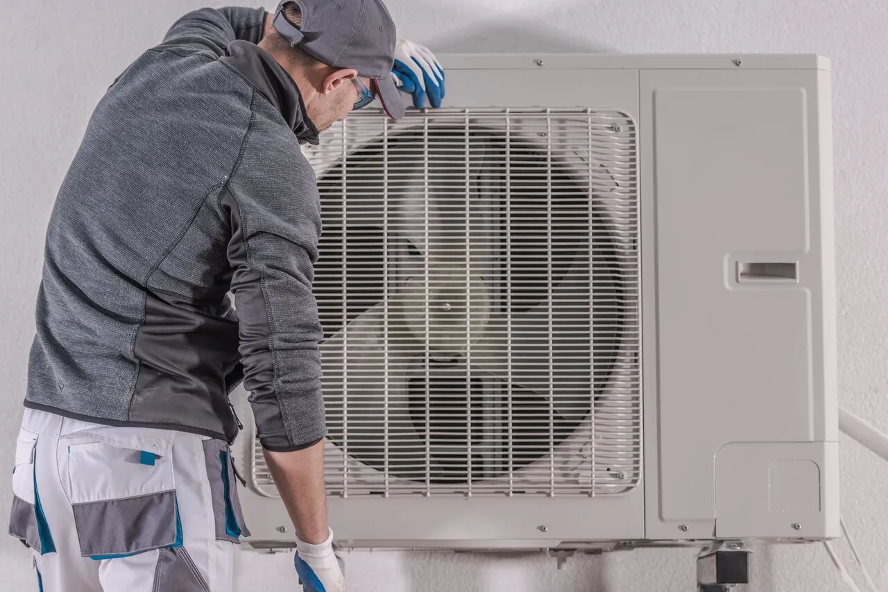 Man checking outdoor AC unit