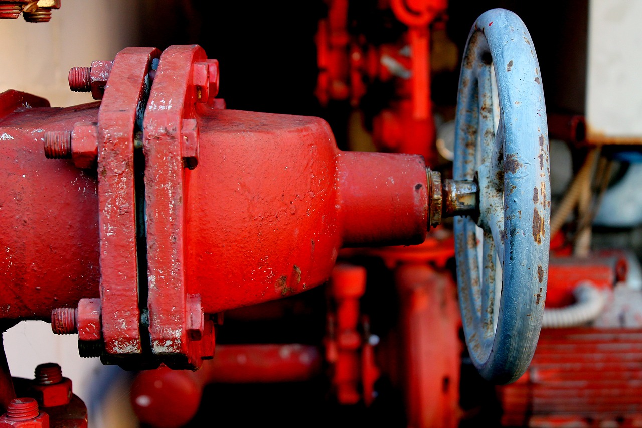 Red industrial valve with blue wheel