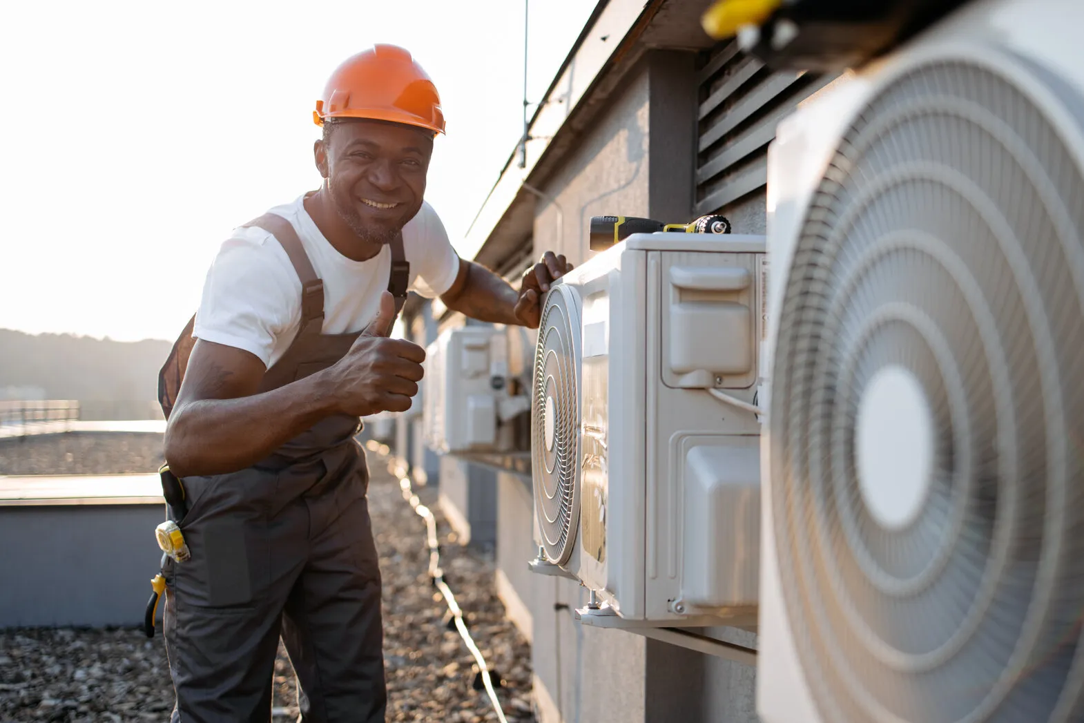 Man giving thumbs up next to AC units