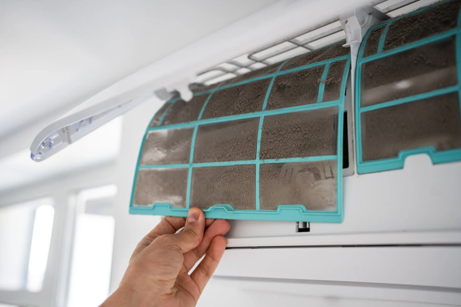 Hand removing dirty AC filter