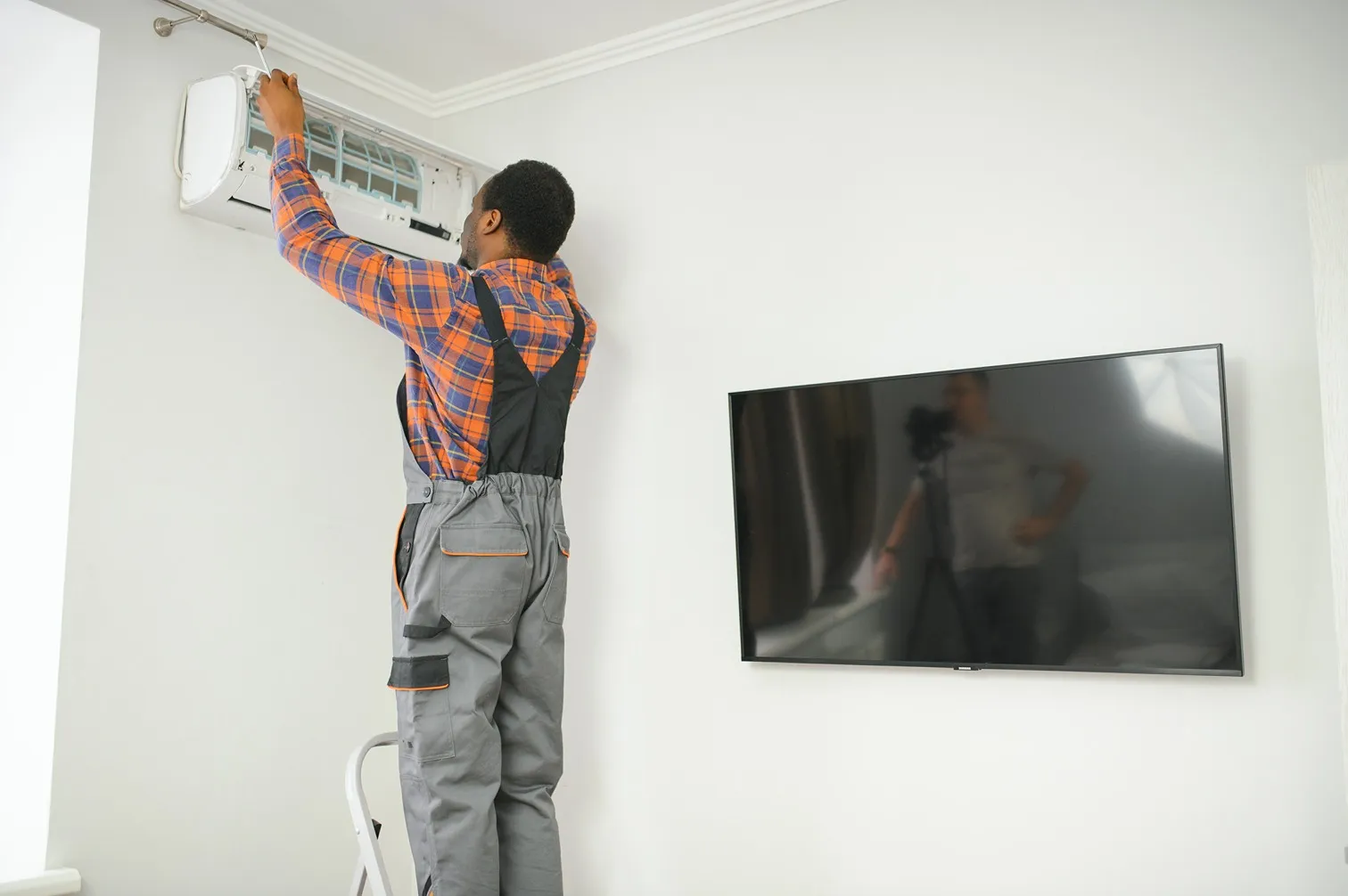 Man servicing an indoor AC unit.