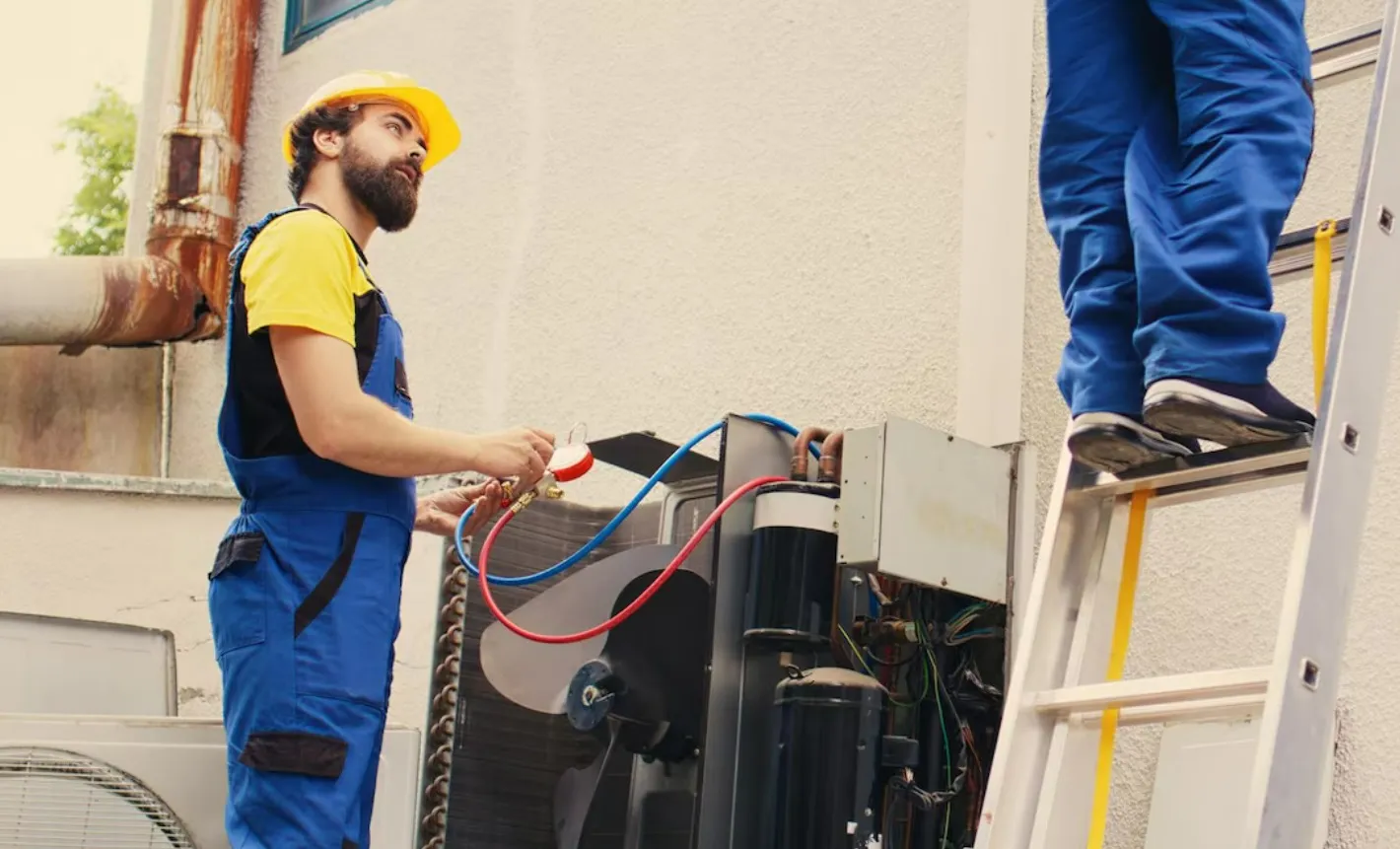 HVAC technicians servicing outdoor unit.