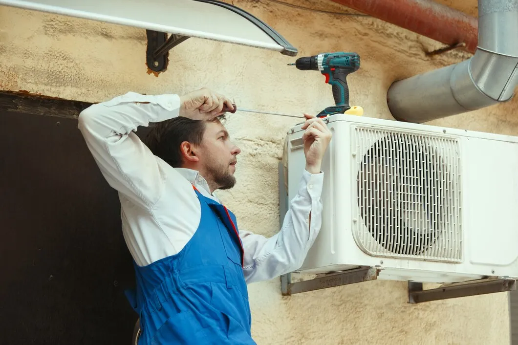 Man working on outdoor AC unit.
