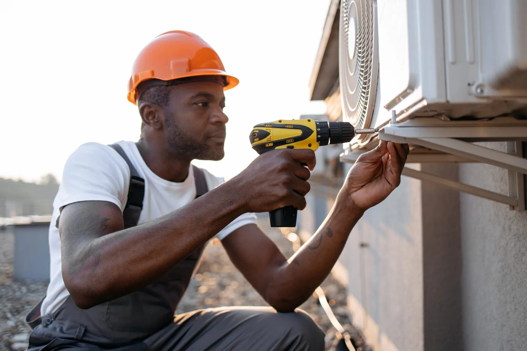 Man drilling into outdoor AC unit.