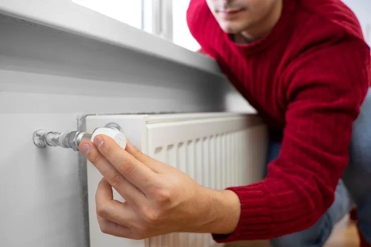 Man adjusting radiator valve.
