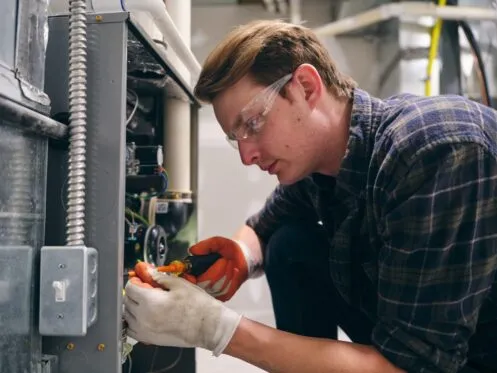 Man with safety glasses working on electrical system.