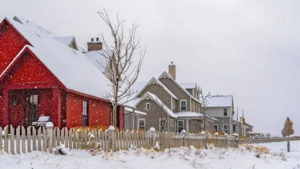 Snow-covered houses with fences.
