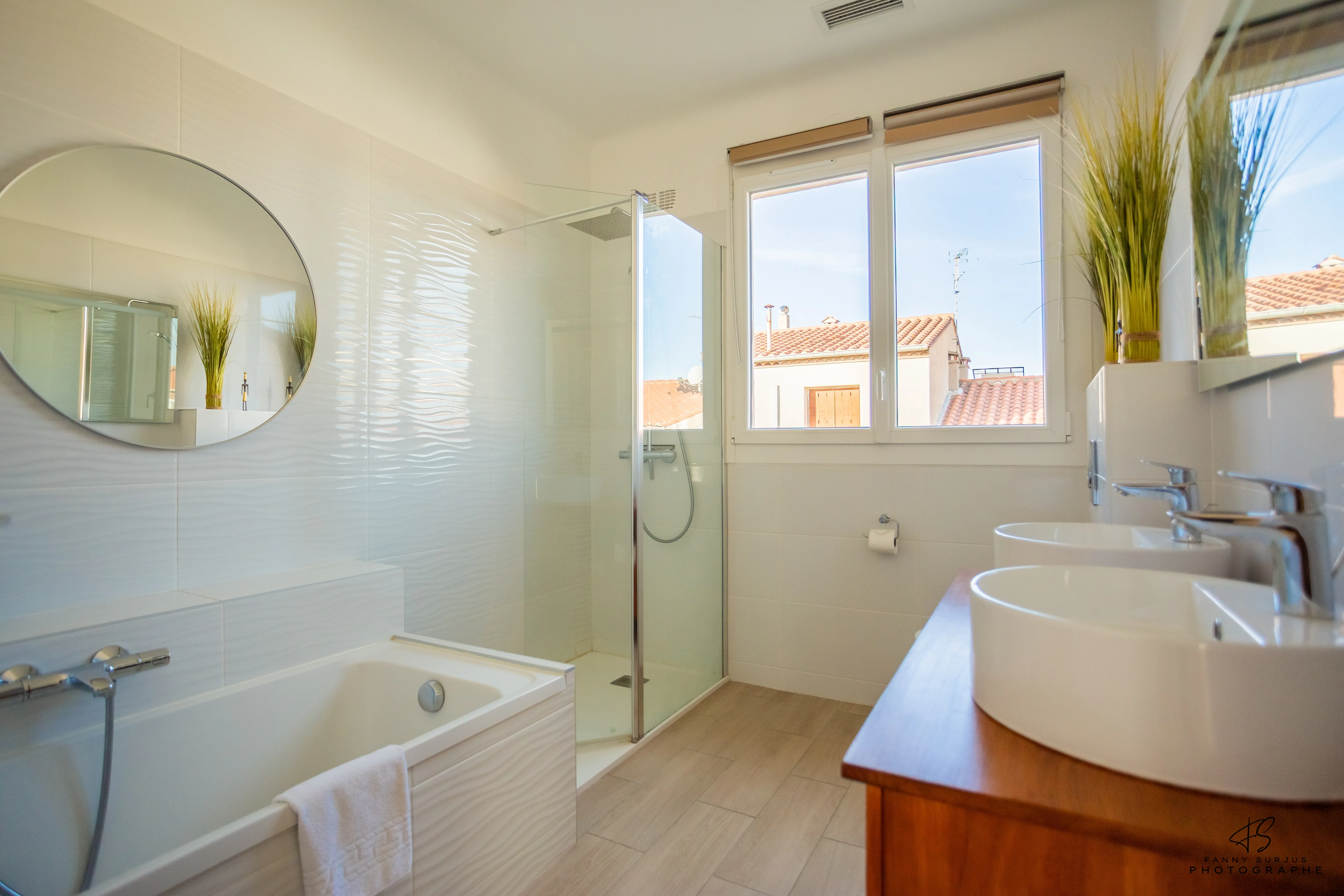 Salle de bain lumineuse avec baignoire et douche