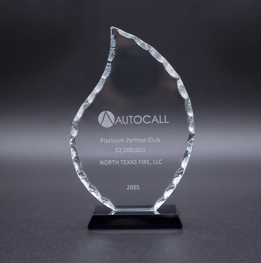 Clear glass award with jagged edges on black base, engraved AutoCall Platinum Partner Club $2,000,000 2025.
