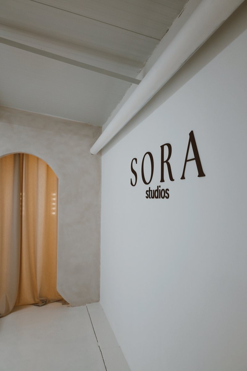 Open studio space with the Sora Studios logo wall and curtained arch
