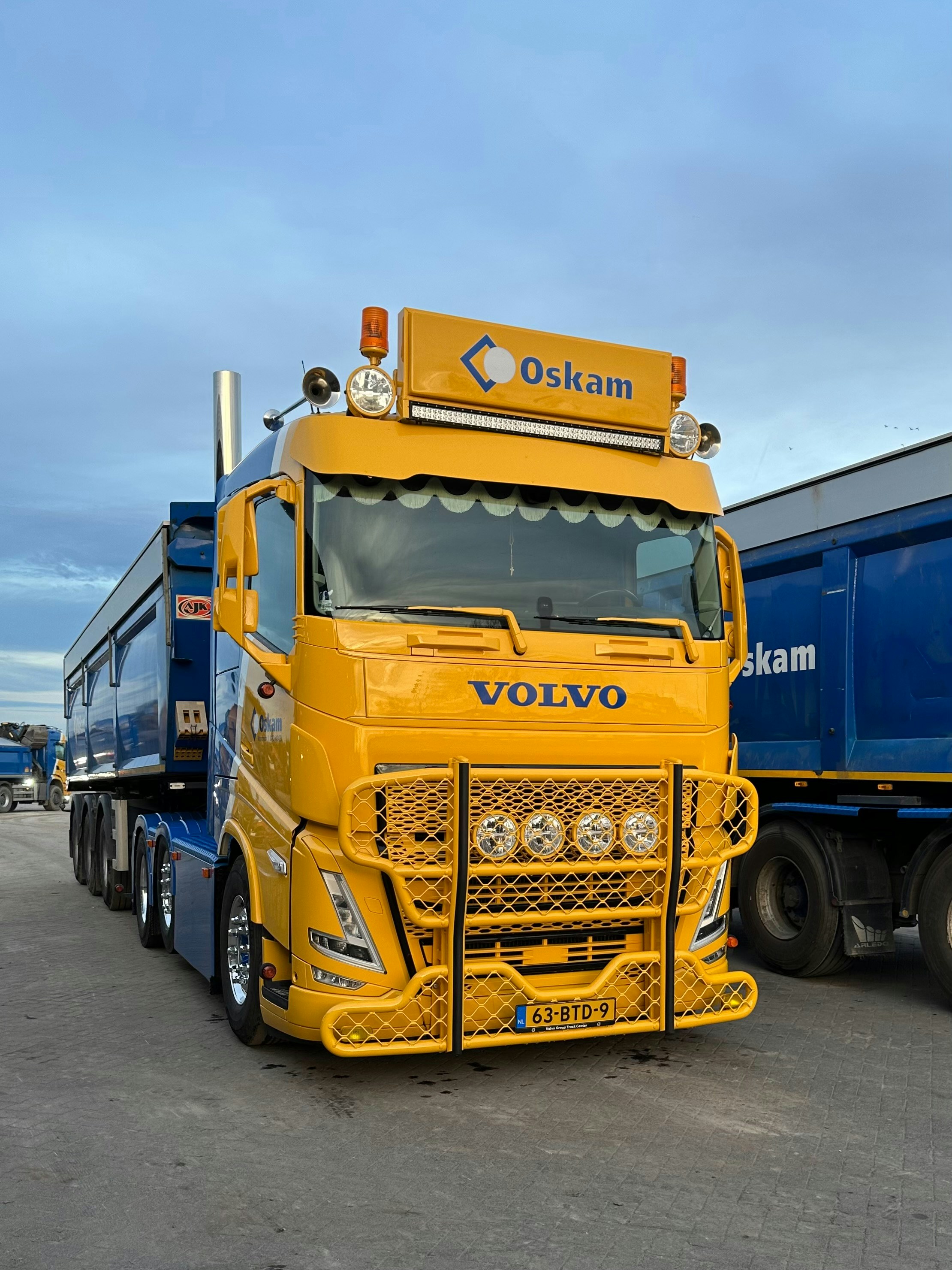 Yellow Volvo truck with trailers