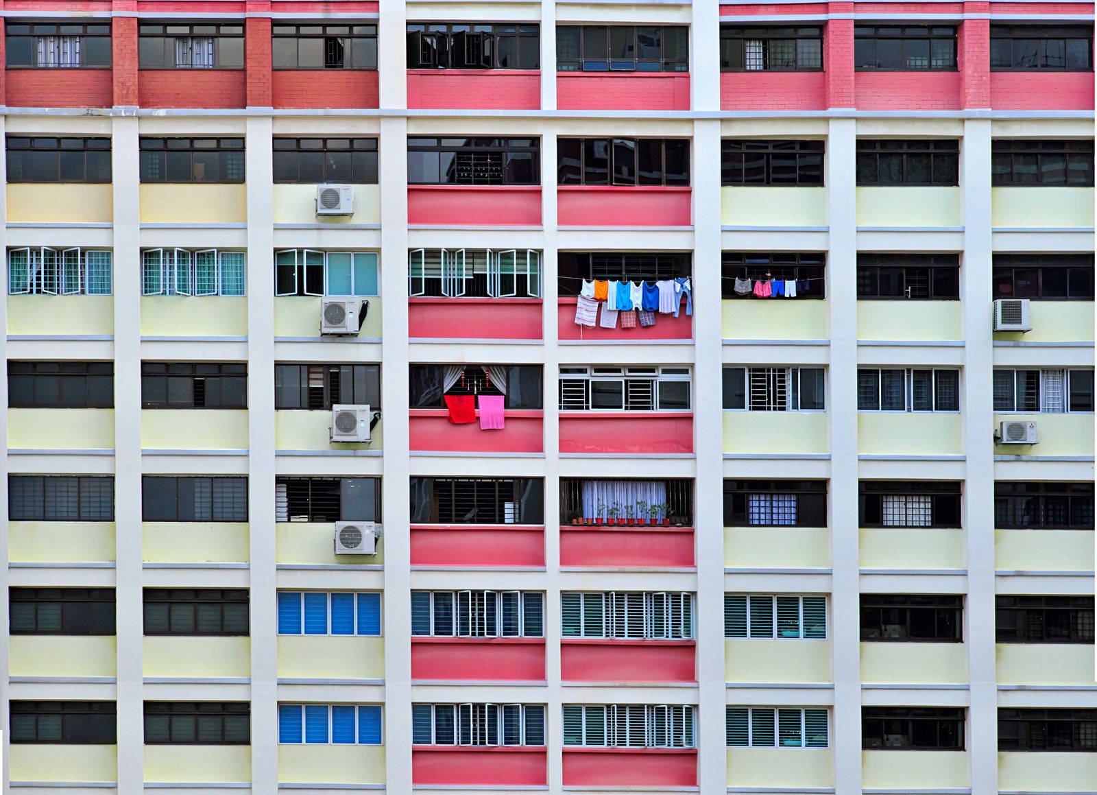 Older resale HDB block facade with laundry poles and air-conditioner units in Singapore