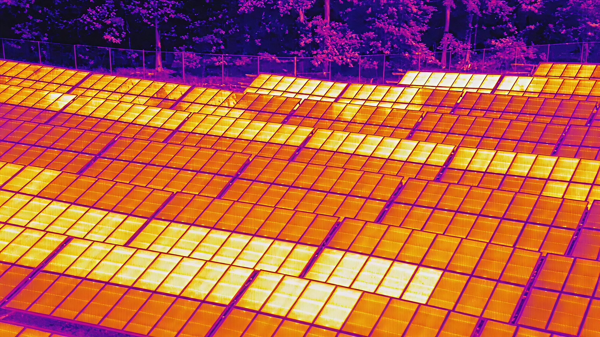 Thermal drone image of solar panel rows showing temperature differences