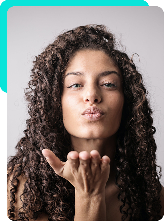 Woman with curly hair blowing a kiss
