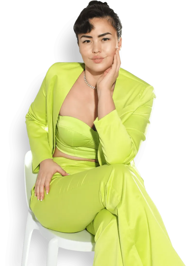 Coach Kate in a lime-green suit, seated on a white chair