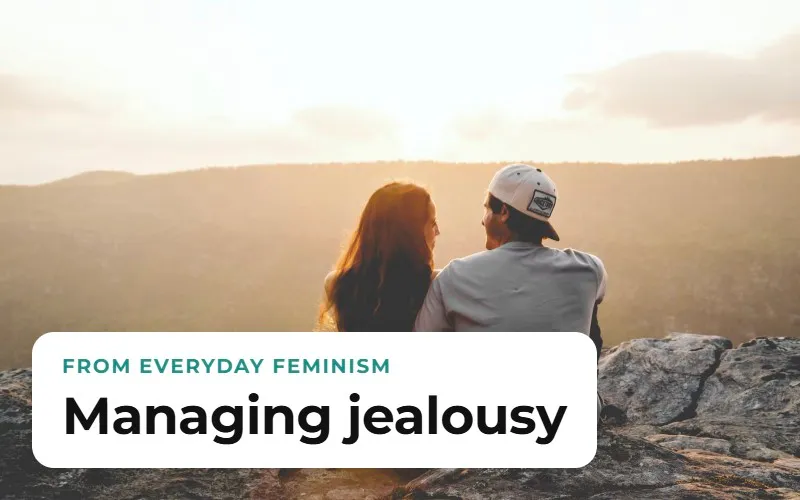 A couple seen from behind, sitting on a rock at sunset