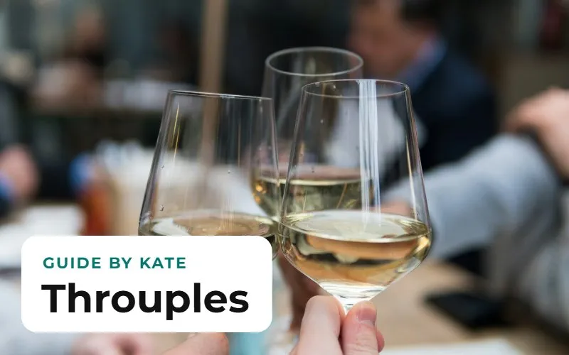 Three wine glasses raised together in a toast