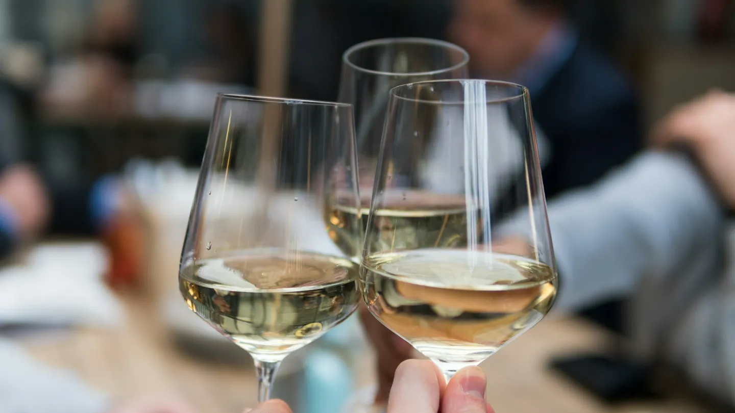 Three wine glasses raised together in a toast