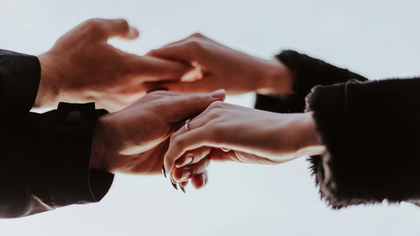 Three hands reaching for each other