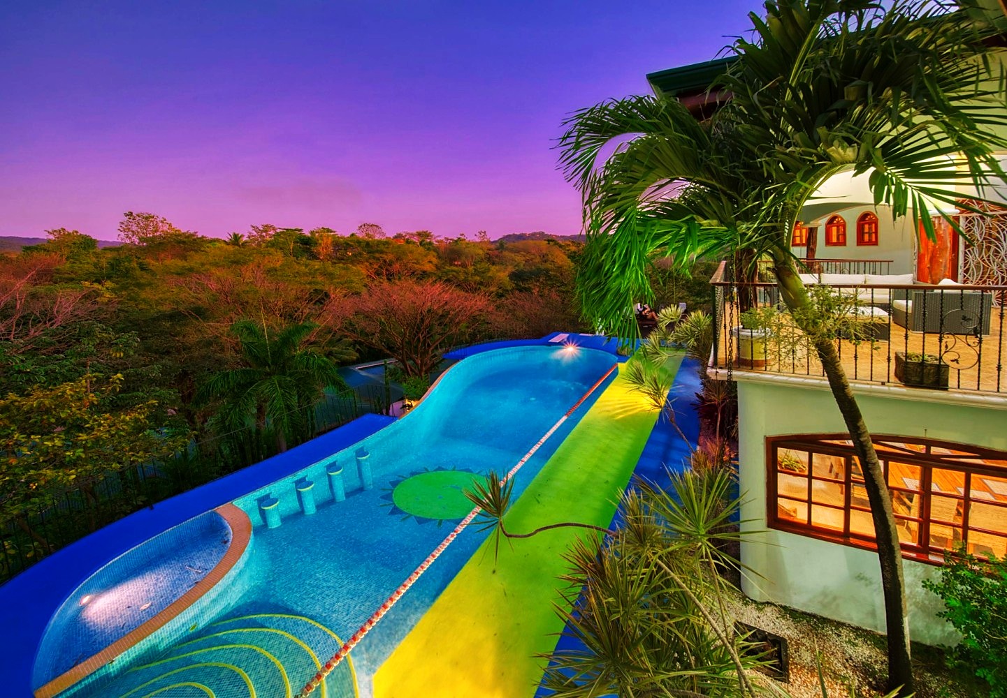 The villa pool at dusk with jungle and mountain views
