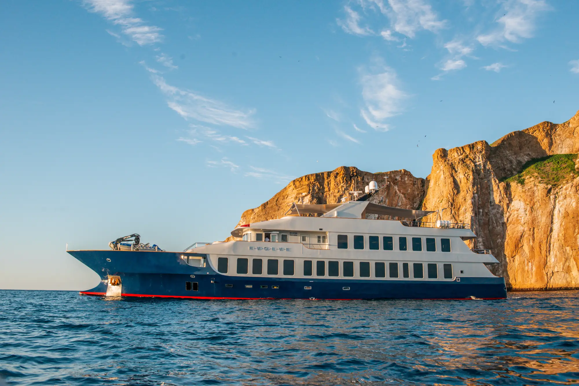 Evolve at sunset beside Galápagos cliffs