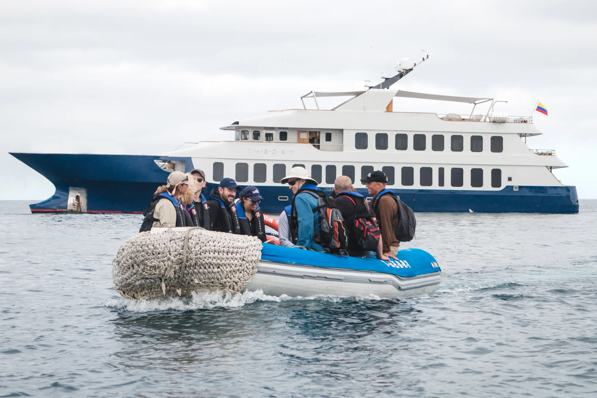 Guests approaching the expedition yacht Theory by Zodiac in the Galápagos