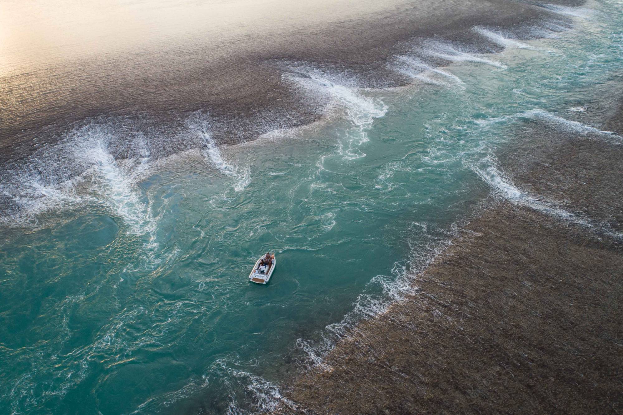 Tender navigating tidal currents pouring off an exposed reef in the Kimberley