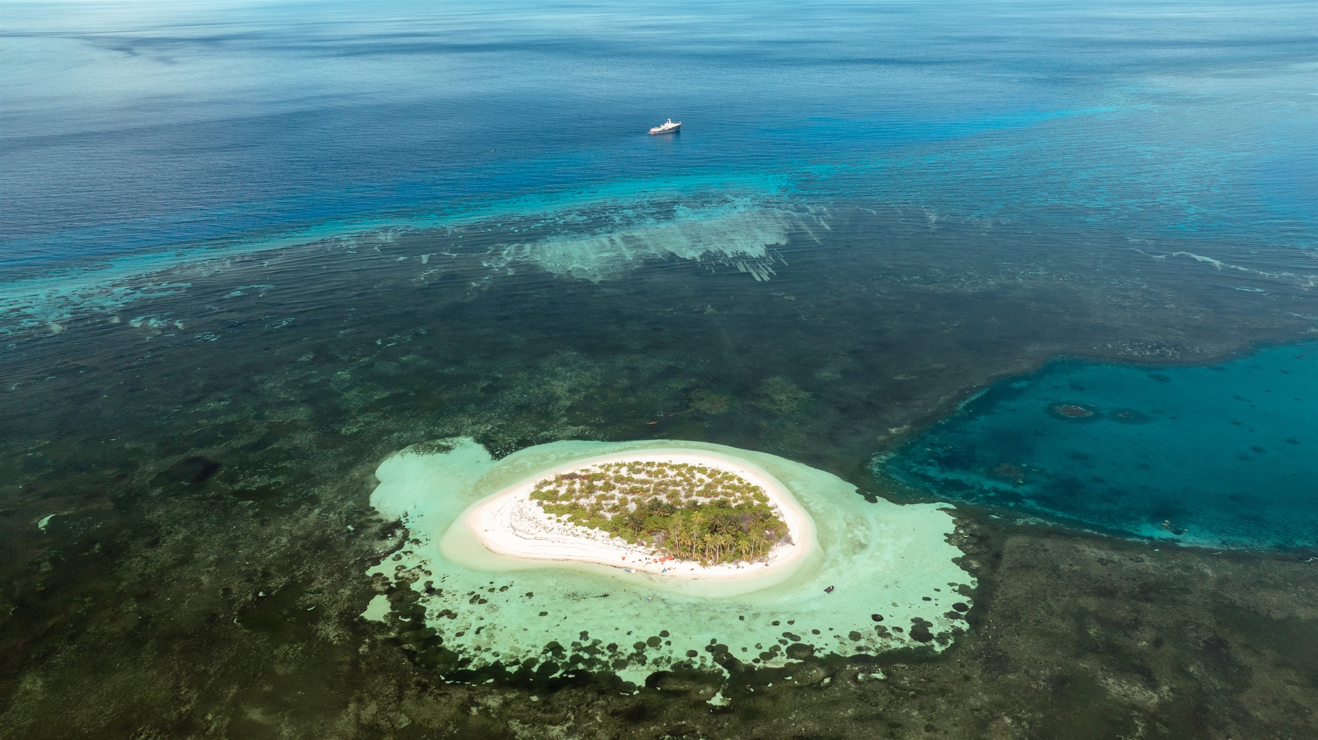 Aerial view of a small coral island ringed by reef in the outer Seychelles
