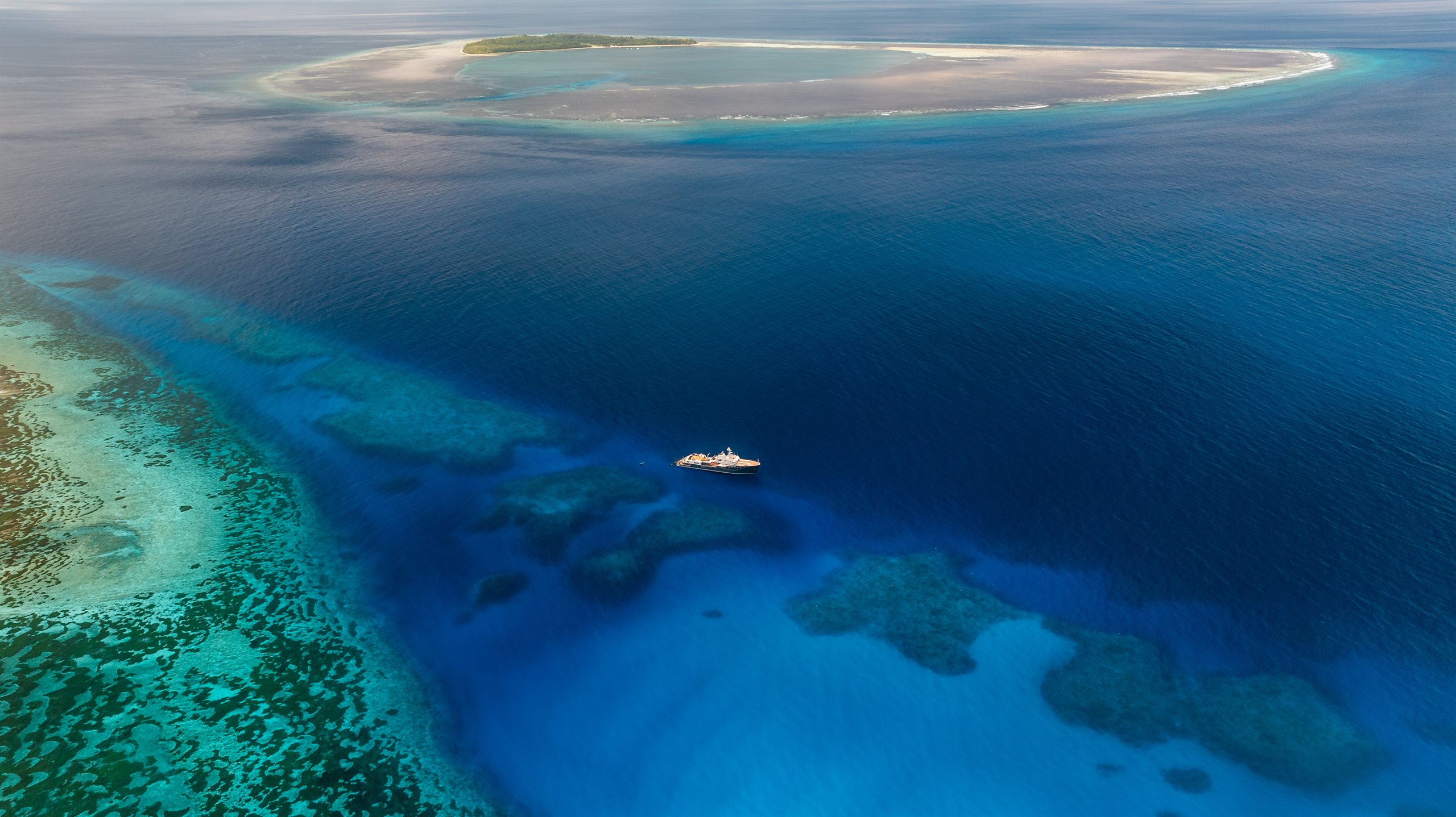 Aqua Lares anchored off a remote coral atoll