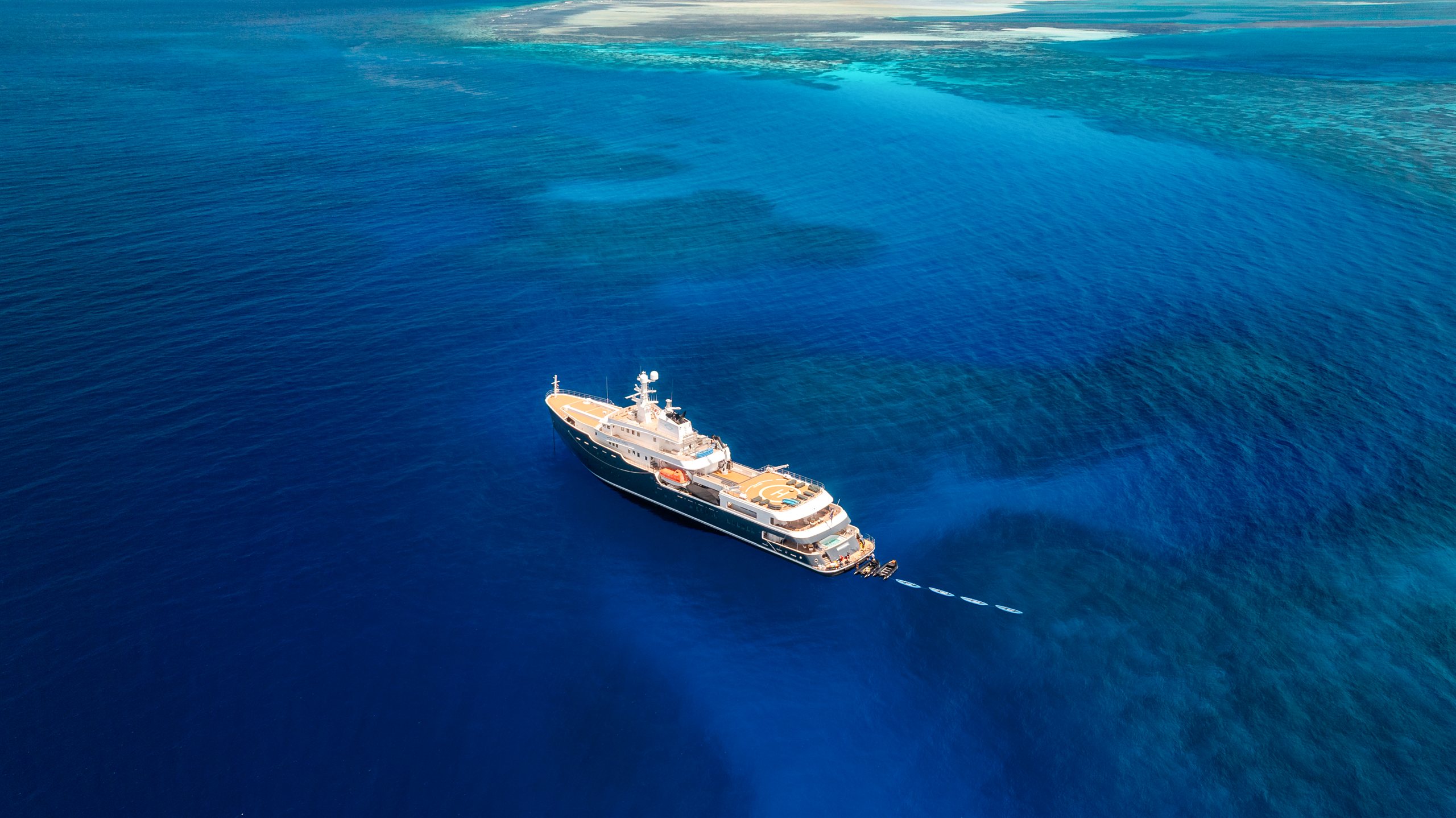 Aerial view of Aqua Lares above deep blue water and reef