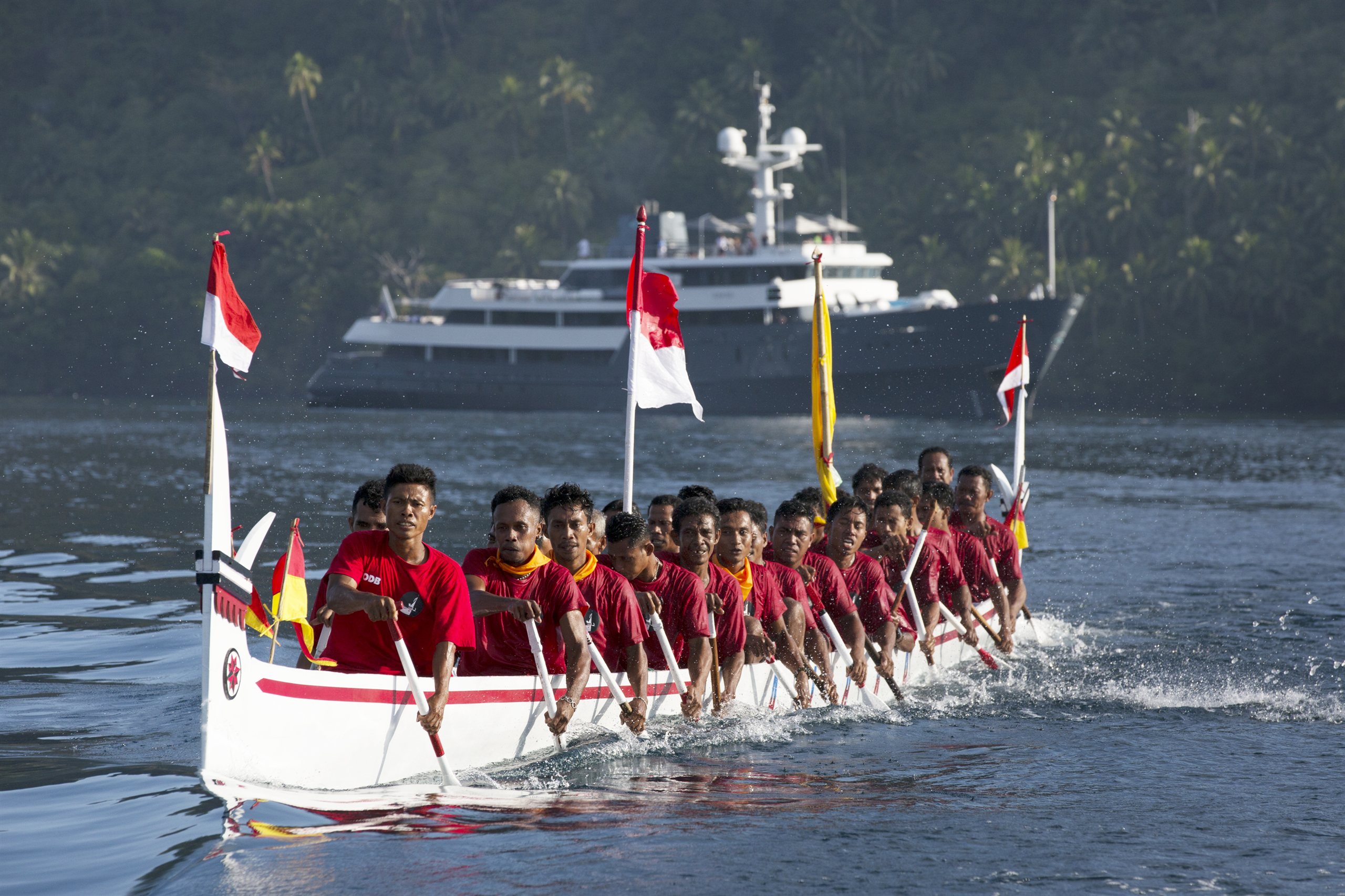 Aqua Blu at anchor in Indonesia with a traditional kora-kora canoe in the foreground