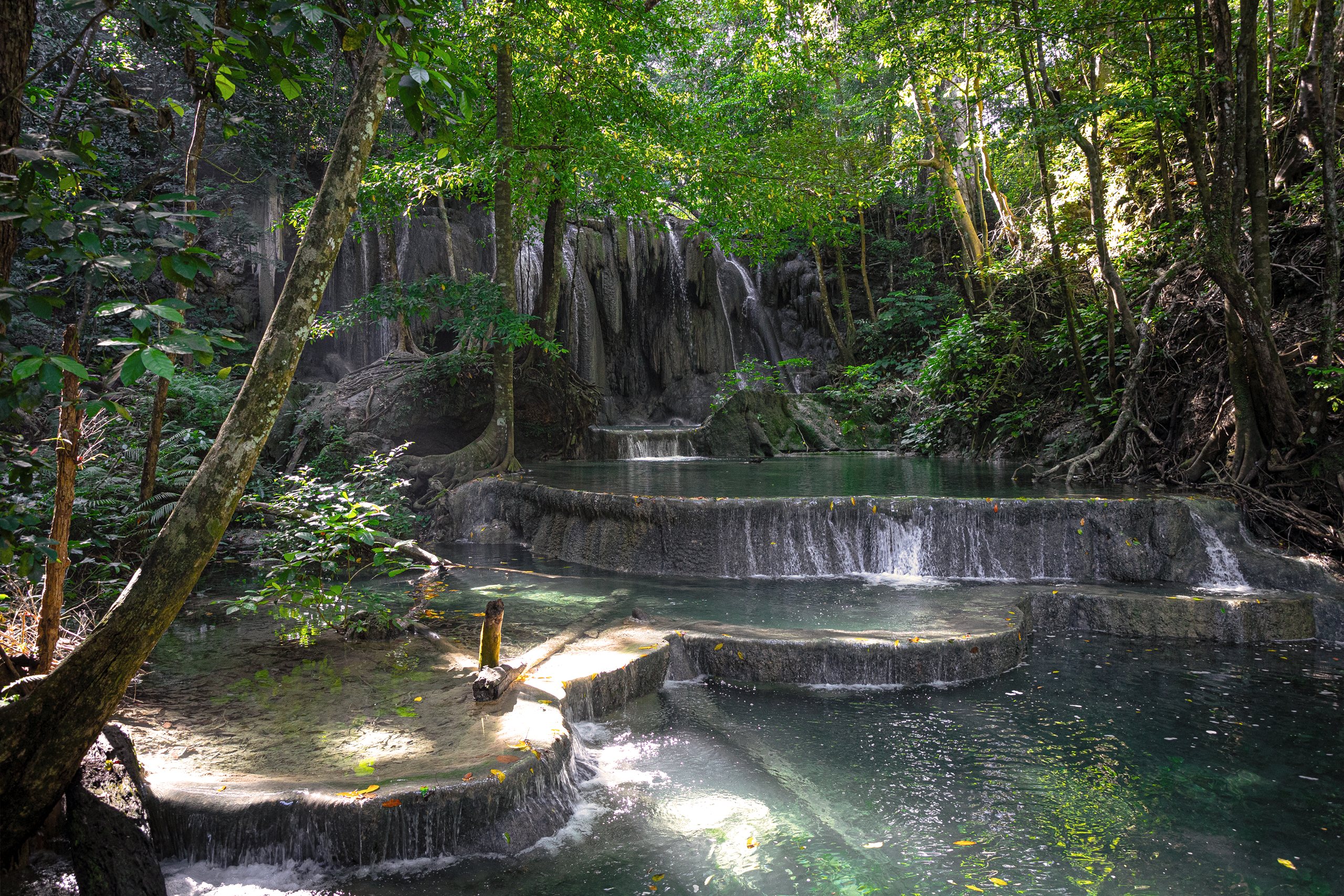 Guests swimming beneath a waterfall on Moyo Island