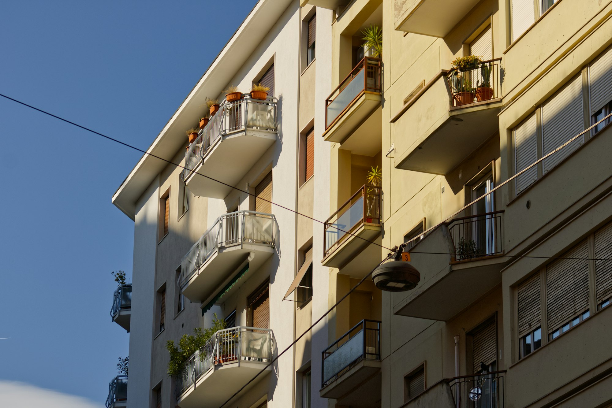 Façades ensoleillées d’immeubles d’habitation avec des balcons fleuris