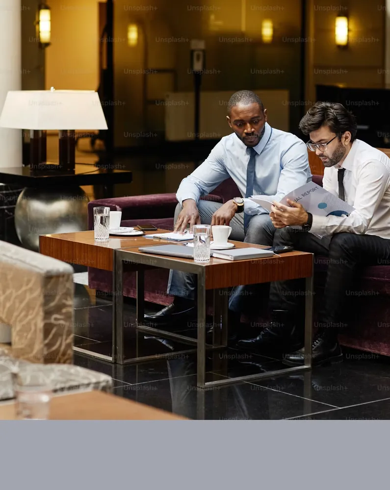 Two colleagues reviewing documents in a bank lounge