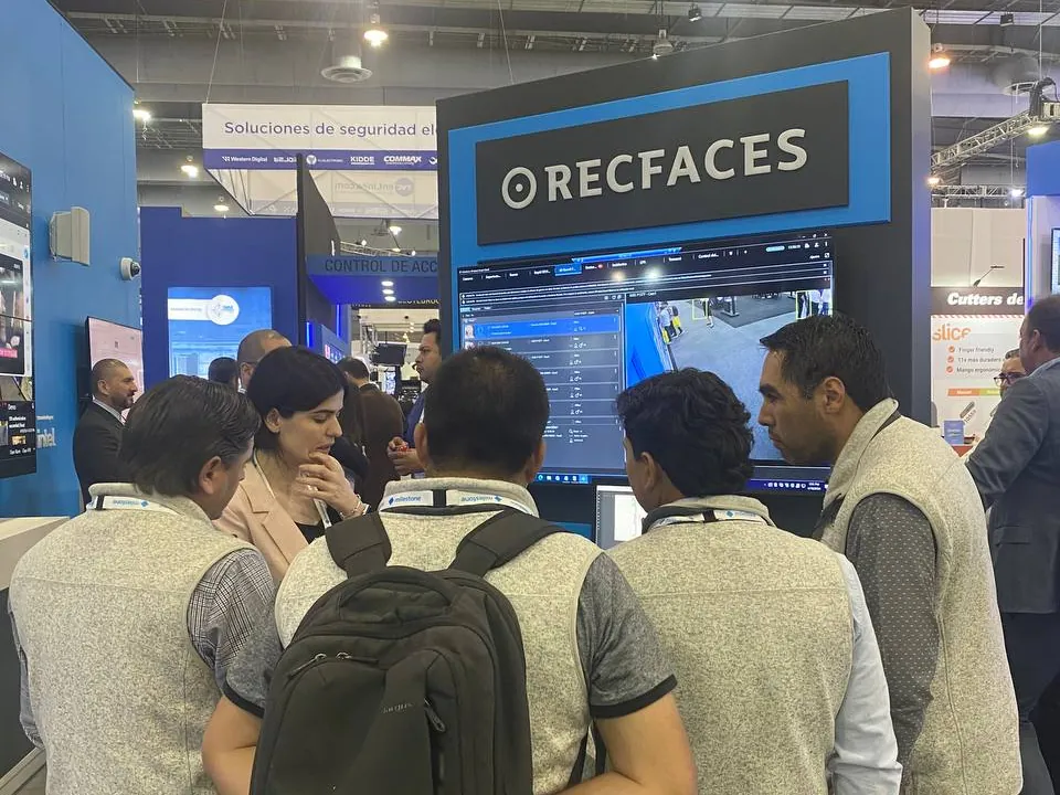 Visitors crowd the RecFaces demo pod on the Milestone stand