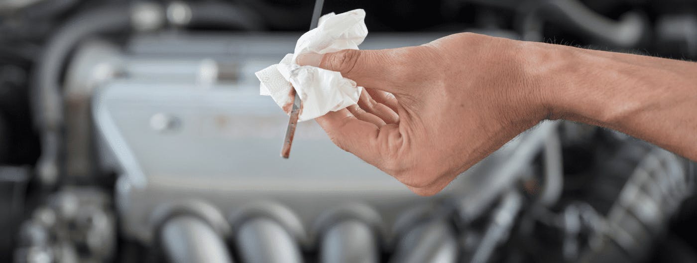 Cleaning the engine oil dip stick to check engine oil levels