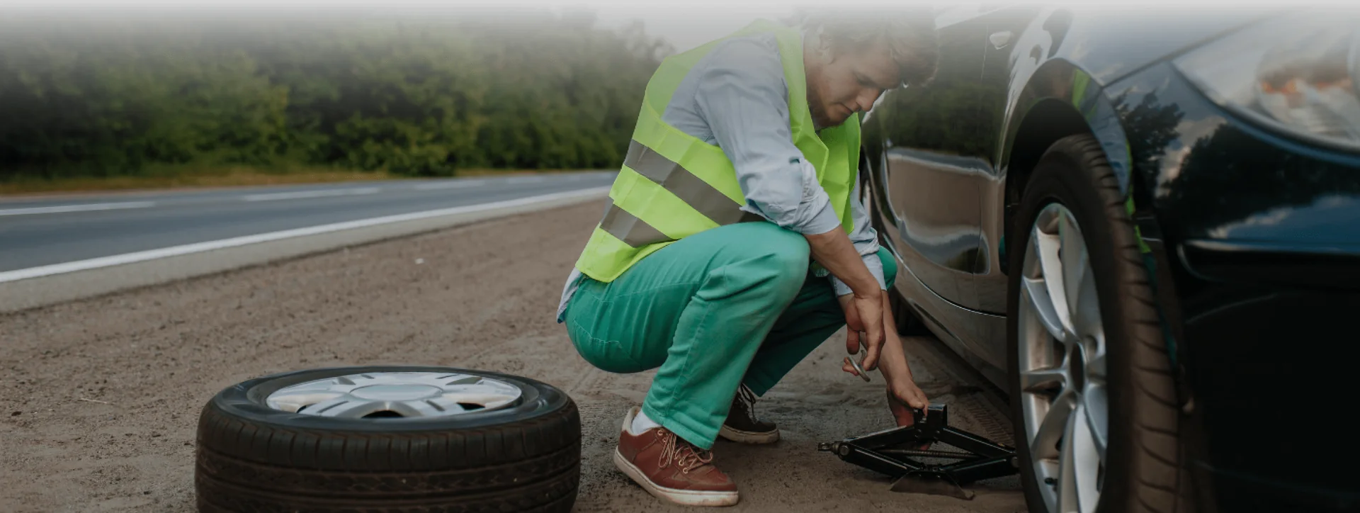 Man changing tyre on the road