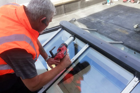 We despatch our roof lanterns worldwide as a kit of parts, and we also provide installation services in the United Kingdom Installer sealing the ridge after capping down the glass