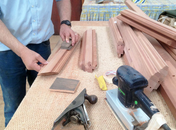 Final hand-sanding of a rafter before painting