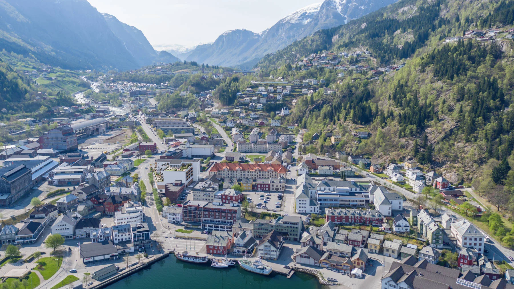 Oversiktsbilde av sentrum, omkranset av fjord og fjell. Domus Gaarden gir deg byliv og storslått natur i samme nabolag.
