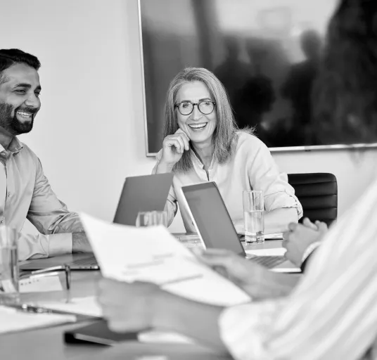 Colleagues discussing documents in a conference room