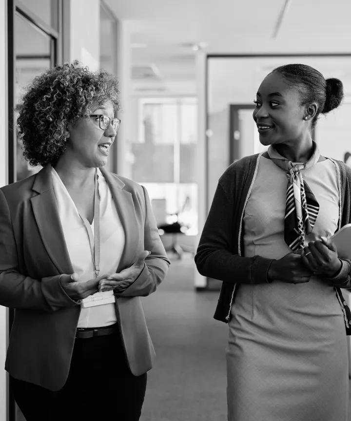Two colleagues talking in an office corridor