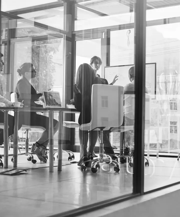 Colleagues collaborating in a glass-walled conference room