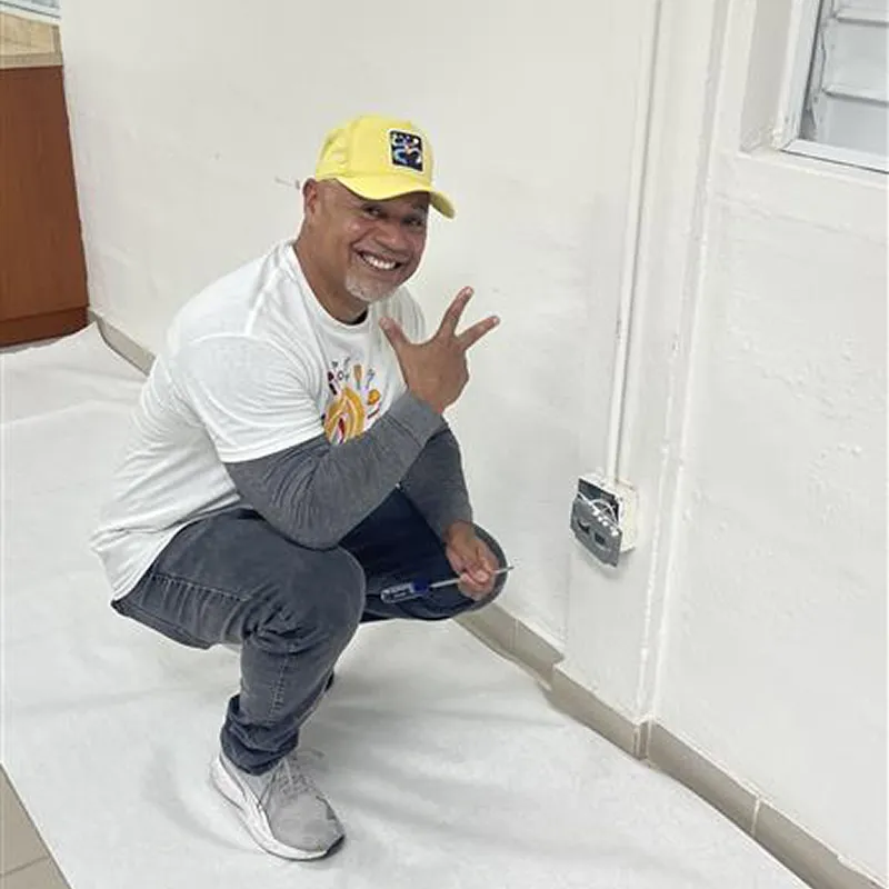 Volunteer smiling while painting a wall