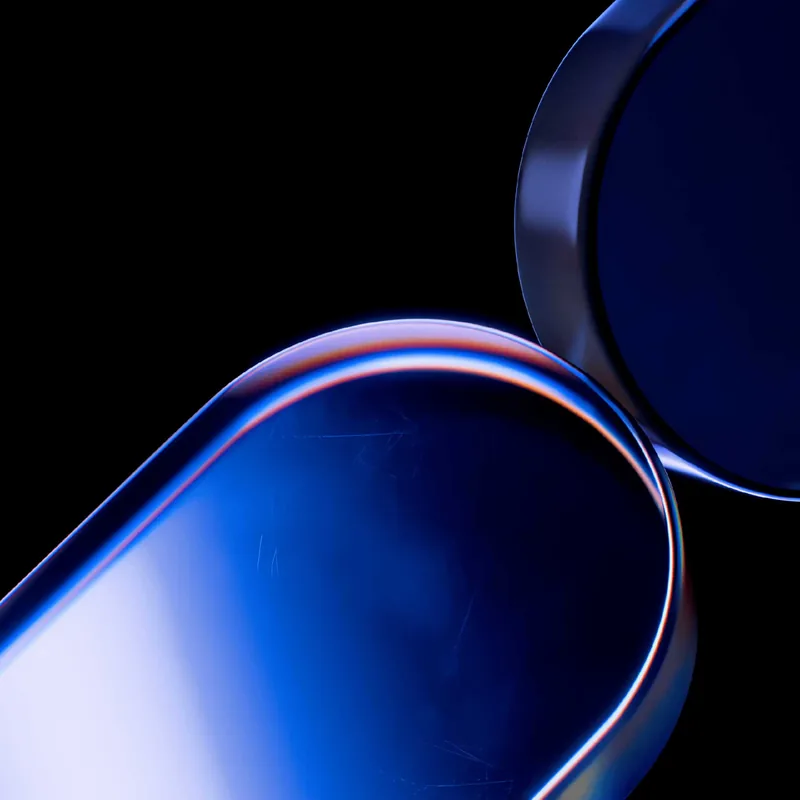 Close-up of two overlapping translucent pills or capsules in shades of blue with a dark background.