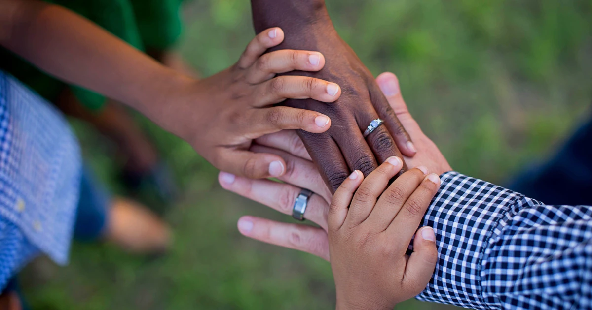 A family placing their hands together
