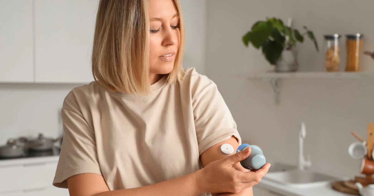 Woman checking a continuous glucose monitor on her arm