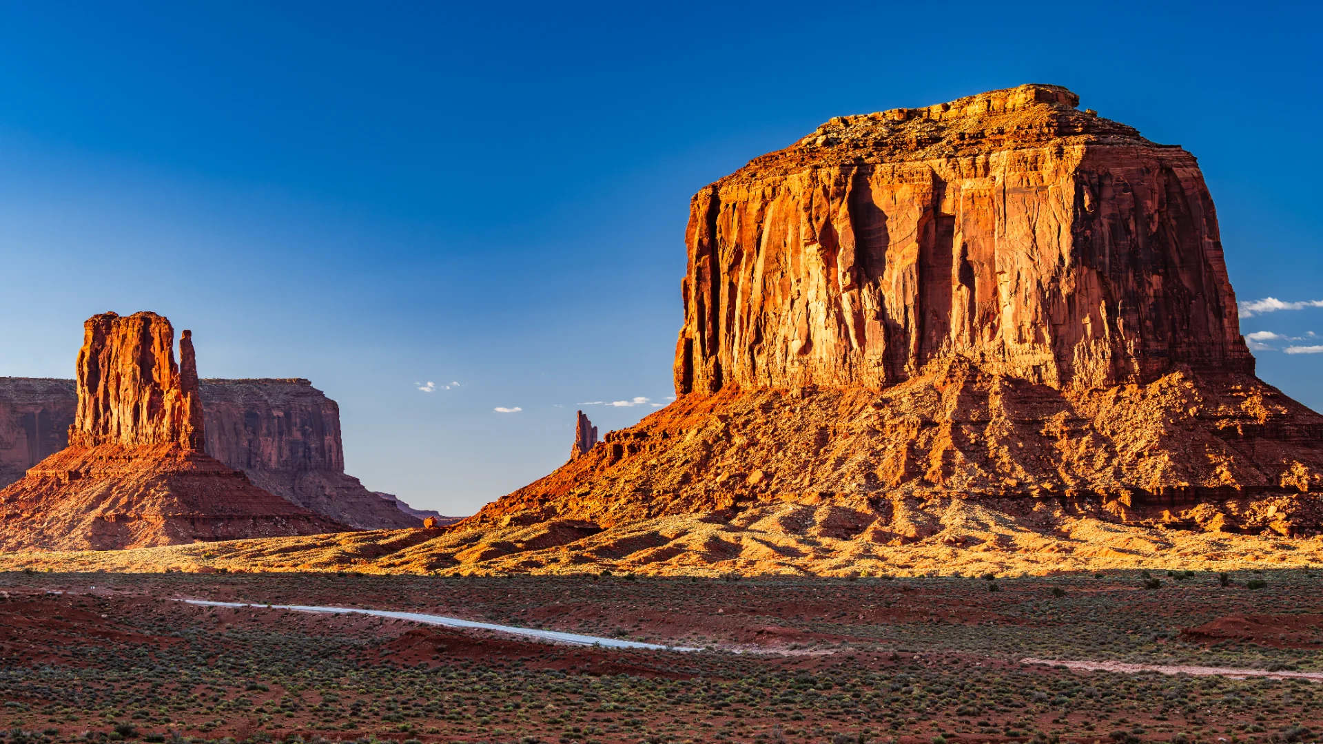 Red sandstone buttes glowing in low sun over open desert