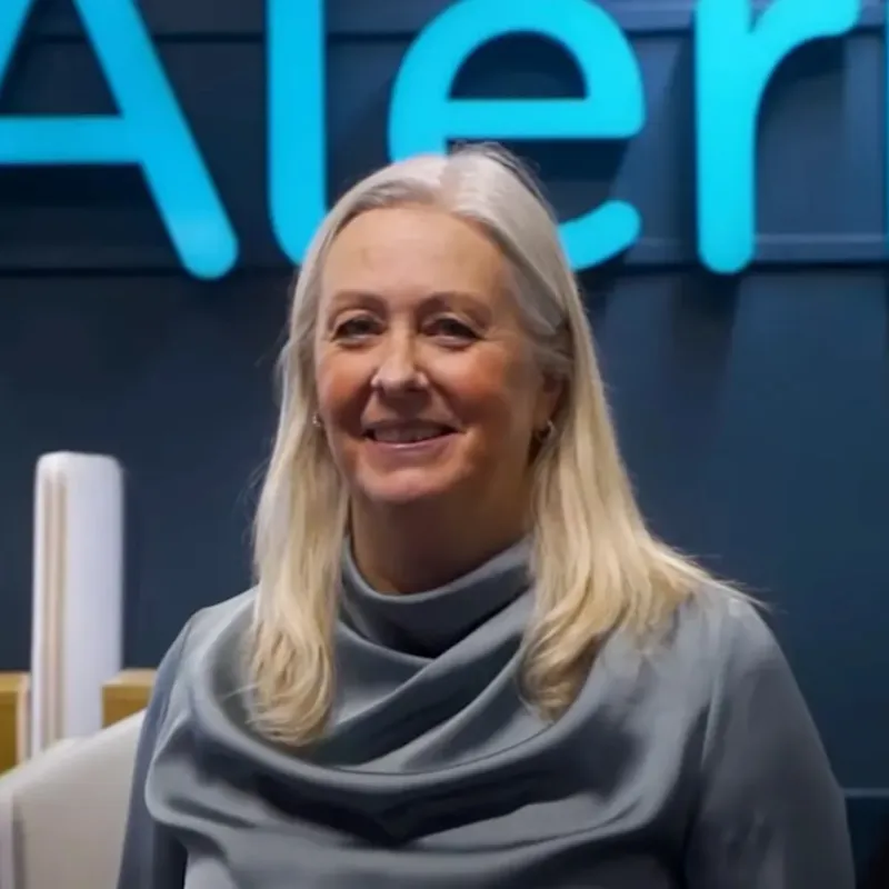 Portrait photo of a smiling woman in front of an Aleris sign